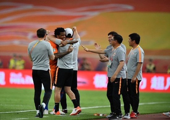 Gil comemora o gol com a comissão técnica do Shandong Luneng
